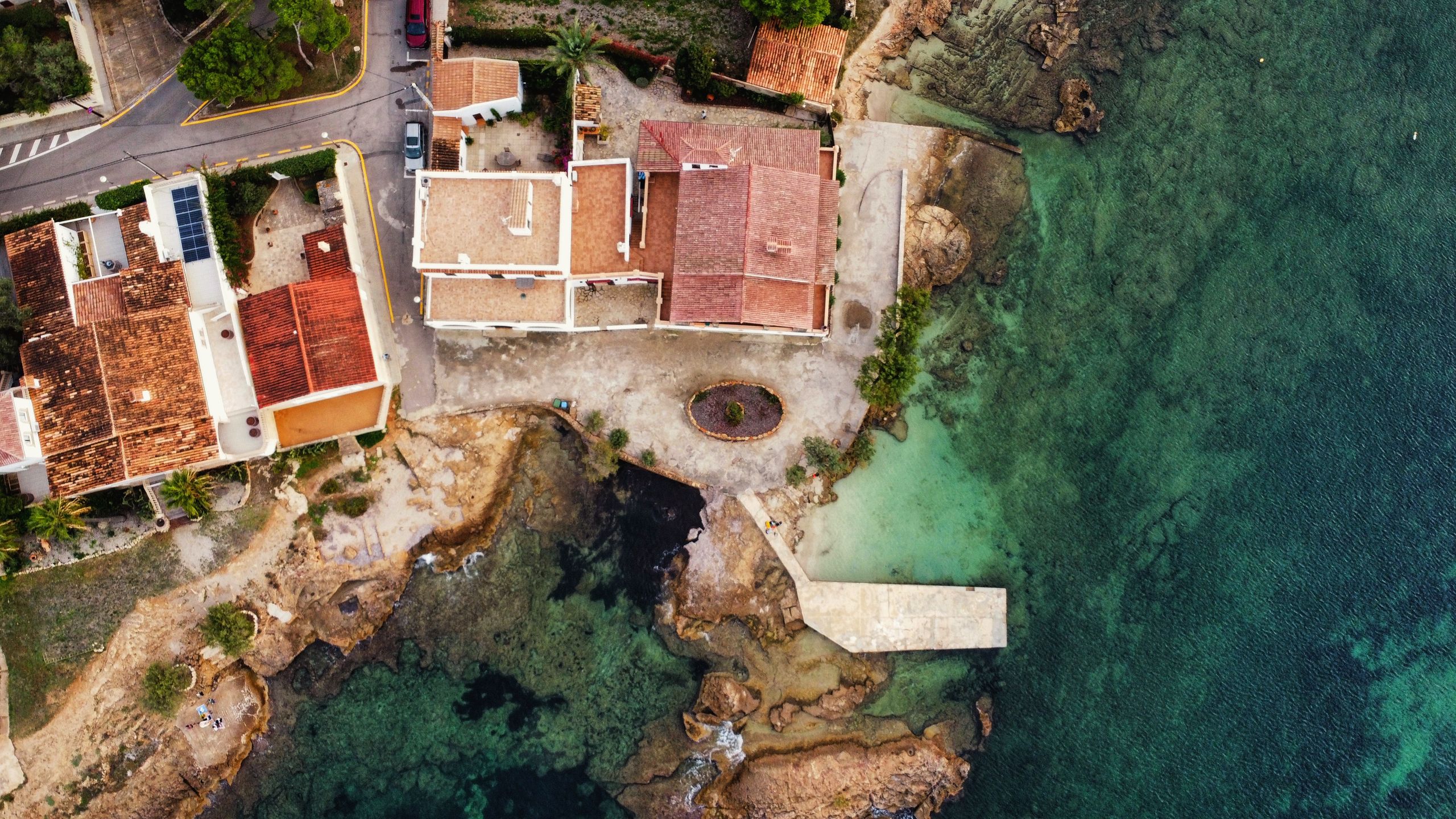 Aerial shot of coastal villas by the sea in Spain, showcasing breathtaking Mediterranean architecture and water views.