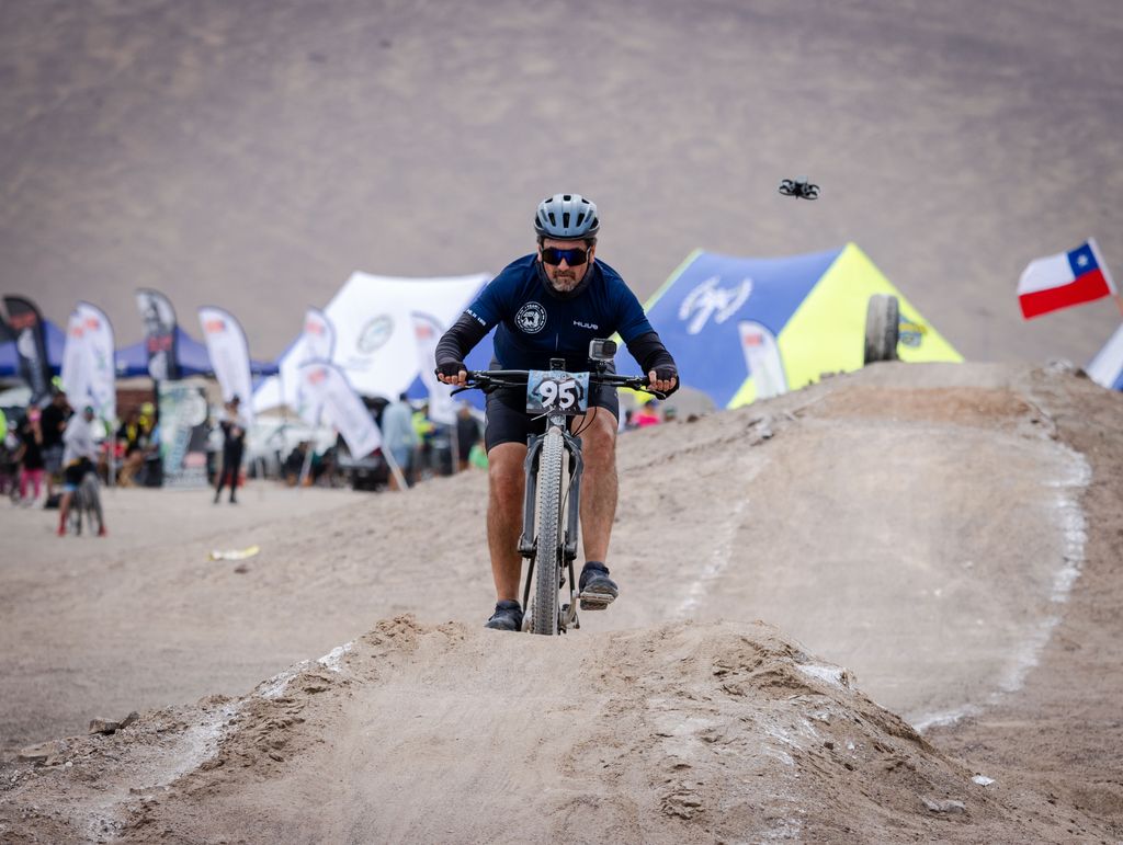 Male cyclist competes in mountain biking race, wearing helmet and sportswear.